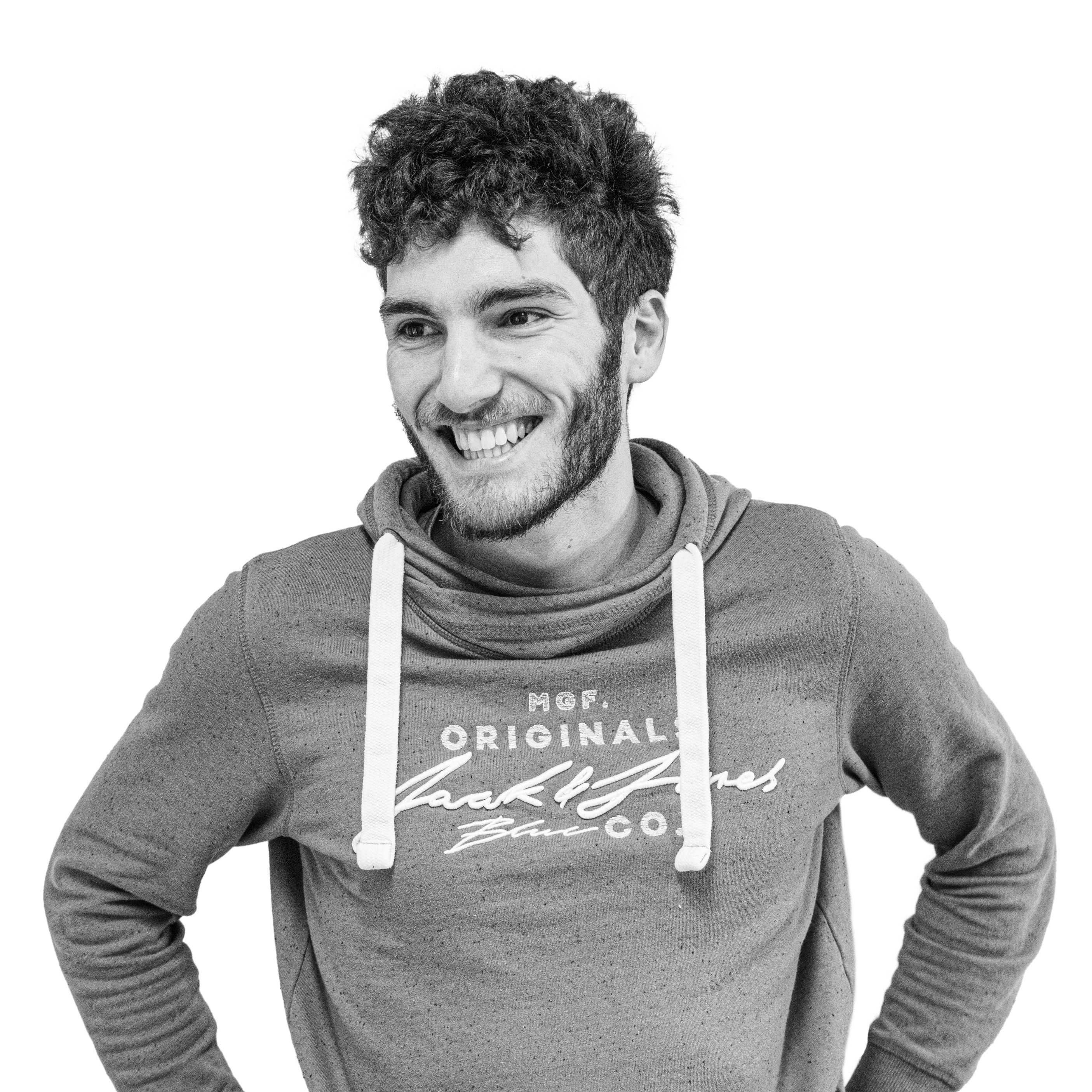 Photo de moi en noir et blanc, souriant dans un style décontracté, portant un sweat